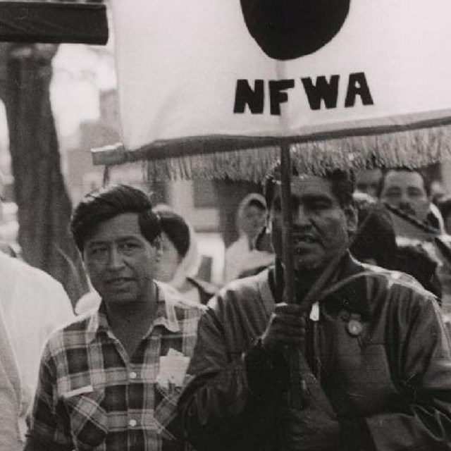 Cesar Chavez and Helen Chavez walk along side others in a march