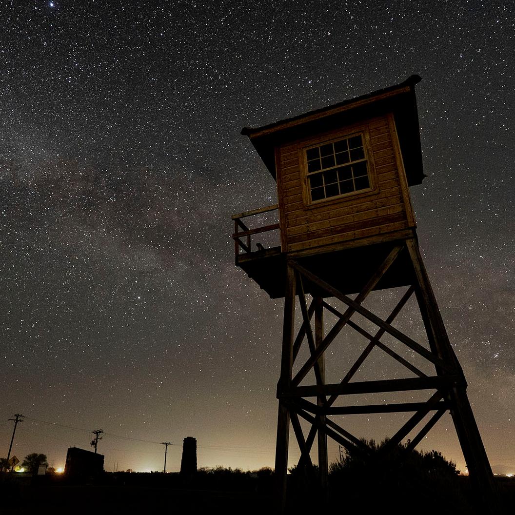 An old guard tower against a starry night sky
