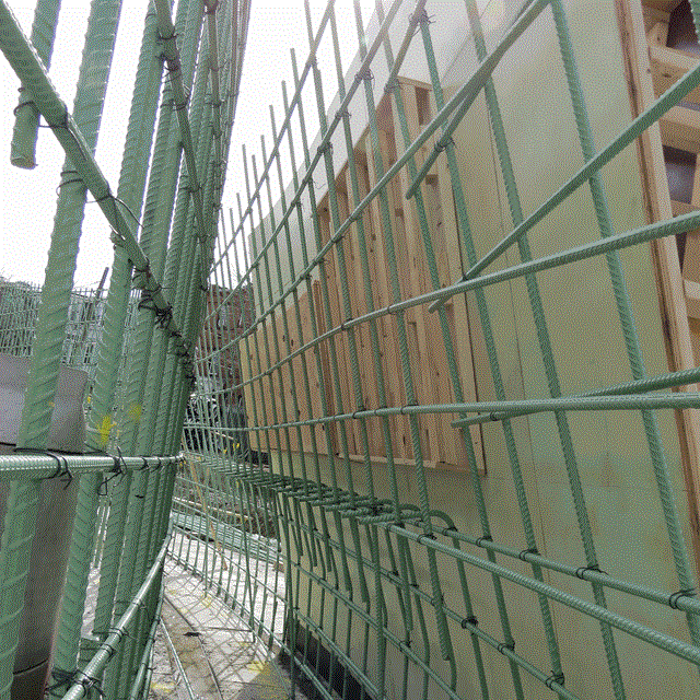 View of inside two walls of rebar with a concrete mold on the curved side