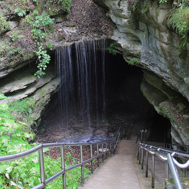 cement walkway leading into a large cave mouth