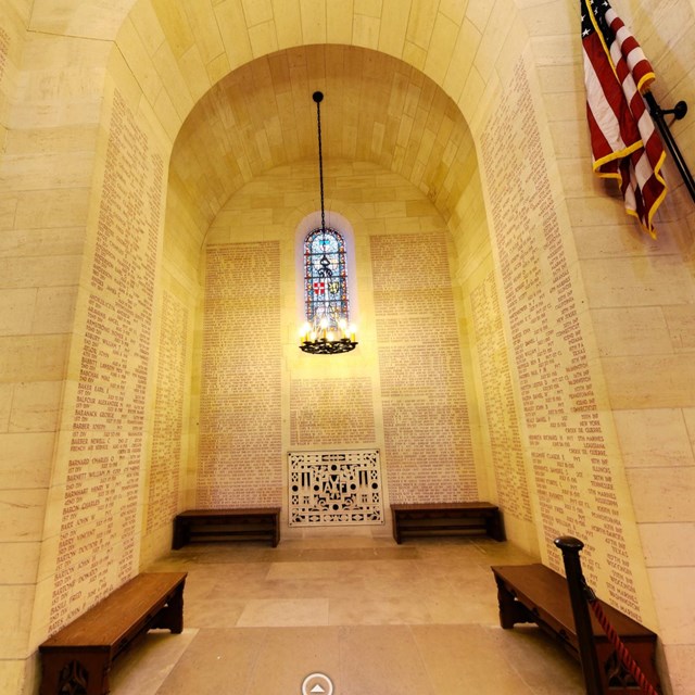 Photograph of chapel transept with stained glass windows and carved list of names