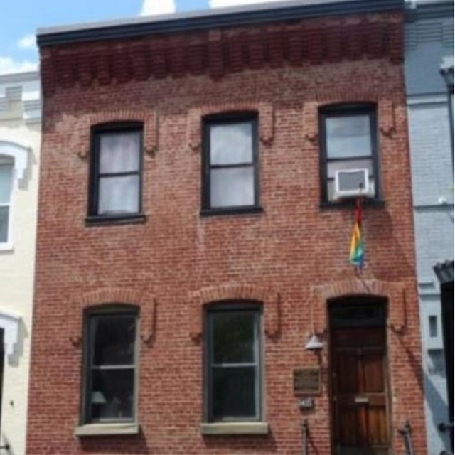 Photo of a brick three story house. 