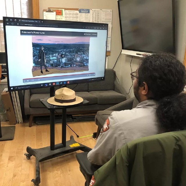 Park ranger watching a monitor displaying a virtual program