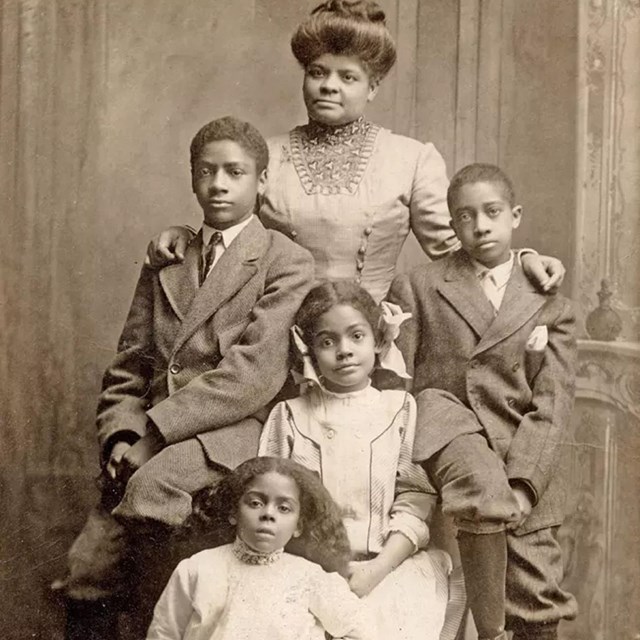 Ida B Wells stands surrounded by two sons and two daughters 