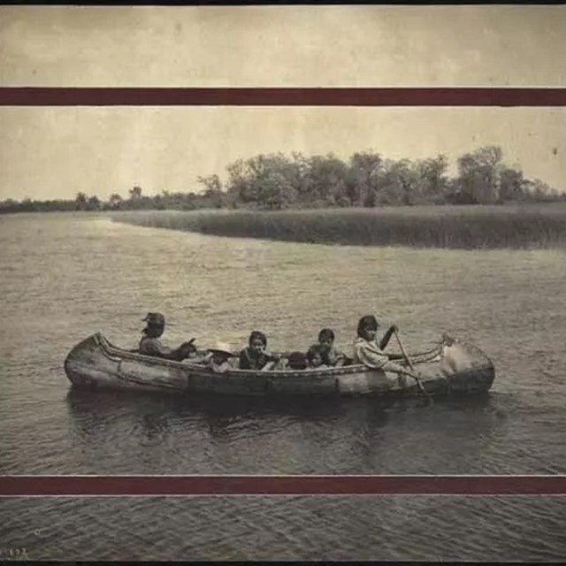 Historic photo of four people in a canoe