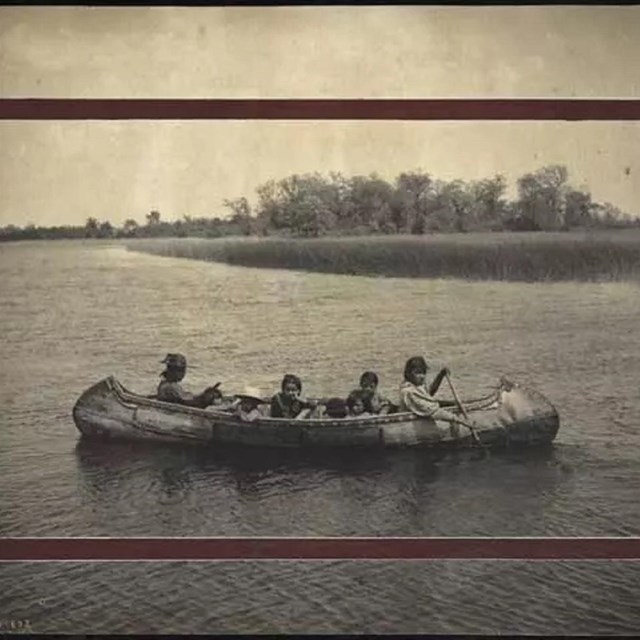 Historic photo of four people in a canoe