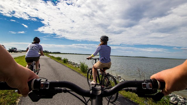 visitors bicycling on a paved path as seen from a bicycler's perspective
