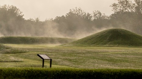 Steam fog rising from grass-covered mounds.