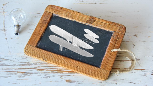 A chalk-outlined plane on a small chalk board