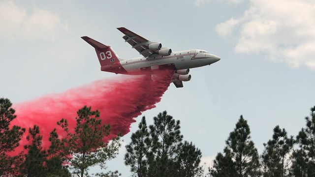 Helicopter with large clouds of smoke in the background