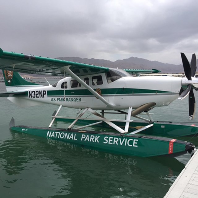 A floatplane for NPS law enforcement sits on the water at a dock