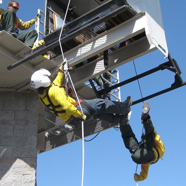 crewmembers train for rappelling off a building