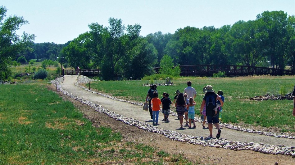 A group walking toward the Animas River along the Old Spanish Trail.