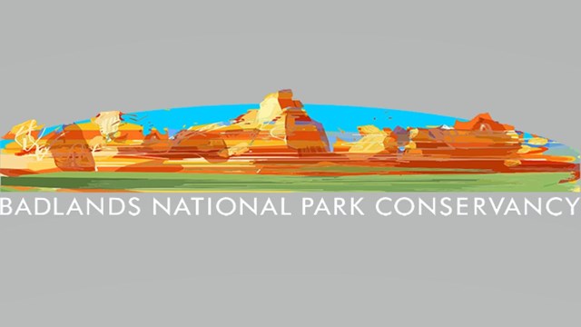 Multicolored layers of jagged badlands formations with blue backdrop