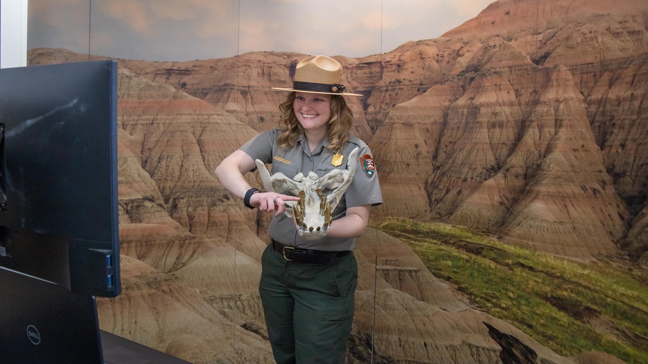 A park ranger displaying fossils to a class virtually.