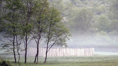 Simple wooden fort sits in misty field