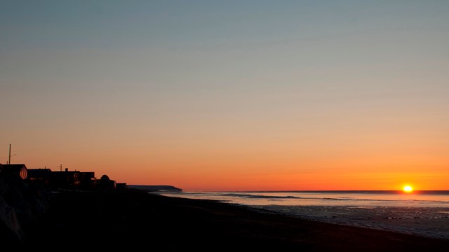 A golden sun dips into the Bering Sea. 