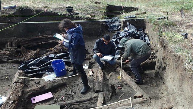 From above, a small multi-room structure is under excavation. 