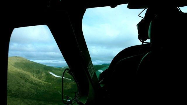 From the back seat of a small aircraft we look out the window onto the rolling tundra. 