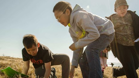 Three young kids participate in a scavenger hunt. 