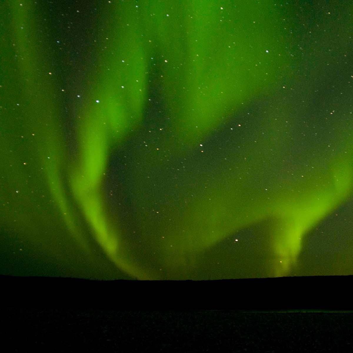 Green streaks of light fill the night sky.