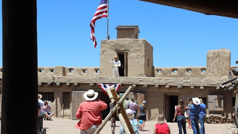 Interpreter at reconstructed Fort presenting guided tour for visitors