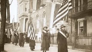 Alice Paul standing next to a NWP Donation Box
