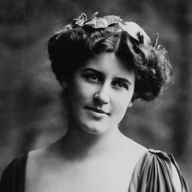 Inez Milholland studio portrait seated with head tilted right