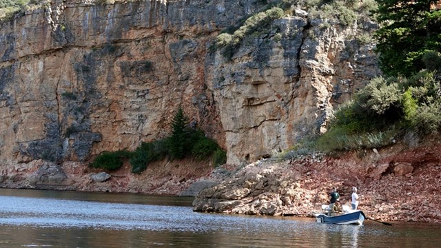 A boat with three men are fishing in Bighorn Canyon.