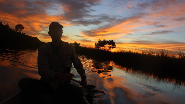 a person canoeing at sunset
