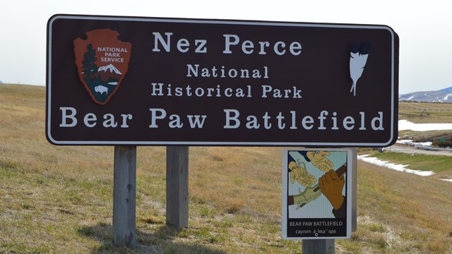 A wooden sign with the words "Nez Perce National Historical Park Bear Paw Battlefield."
