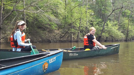 two girls canoeing on a river