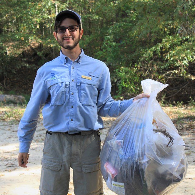 volunteer holding a bag of trash