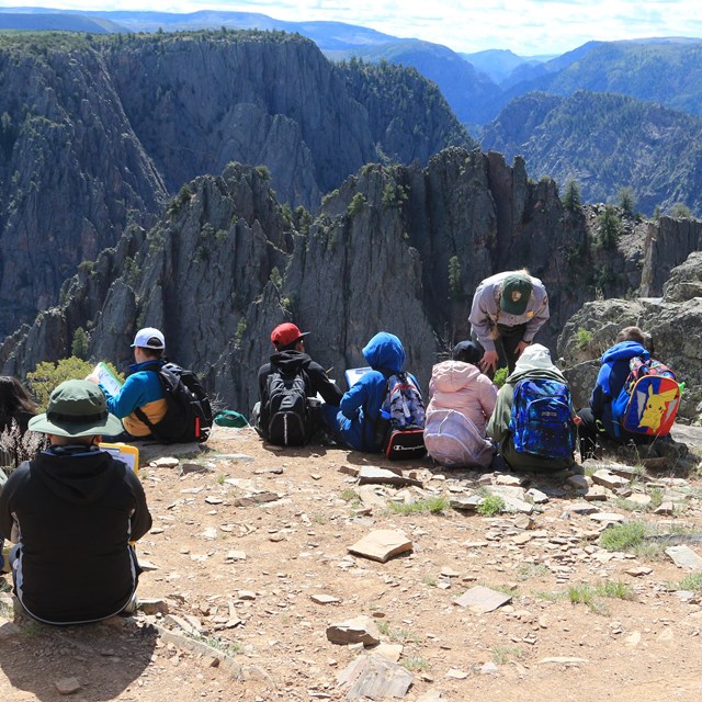 A ranger leads a field trip with school children at a canyon overlook