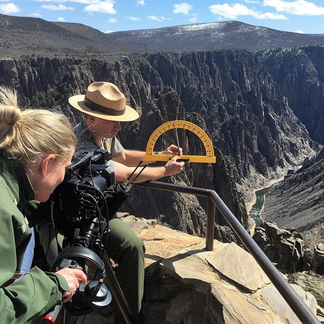 A videographer films a ranger presenting an educational program