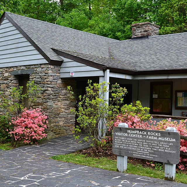 Humpback Rocks Visitor Center, a small, classic national park style building, with azaleas blooming.