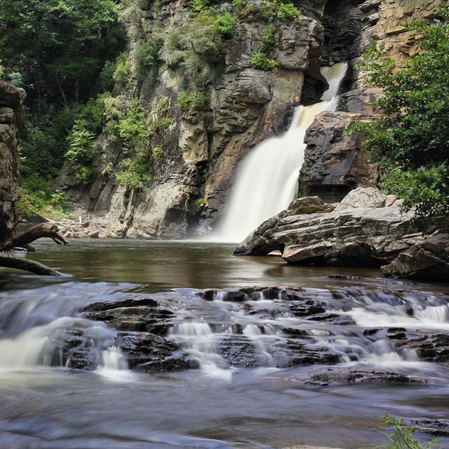 A waterfall plunges over a rock outcrop.