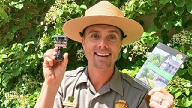 Ranger Andy holding the new Passport Book and Stamp