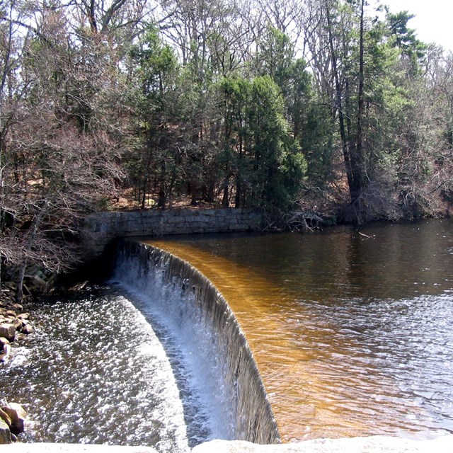 Dam at Slatersville with water flowing over it
