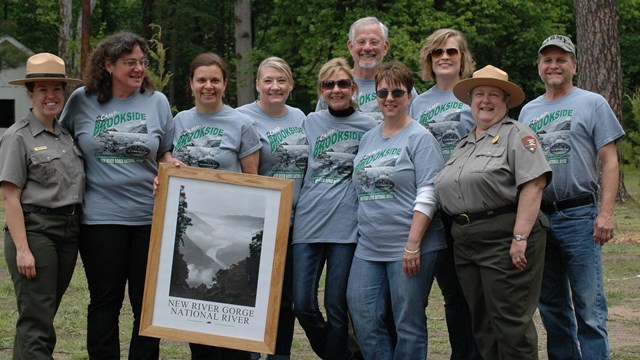 Freinds group members pose with a framed photo
