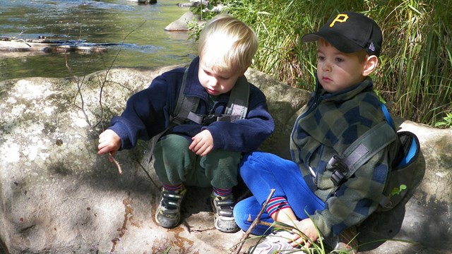 Two boys playing by the river.