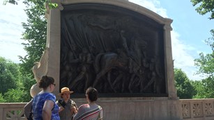 Ranger speaking with two visitors at the Shaw Memorial