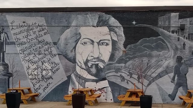 Mural of Frederick Douglass with his portrait in the center and a quote to the left.