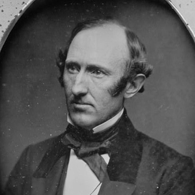 Black and white photo of Wendell Phillips, with short dark hair and a dark suit.