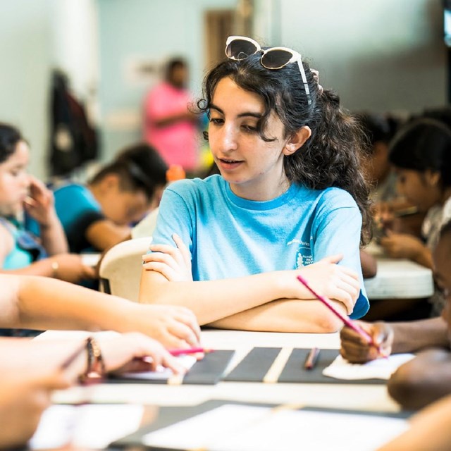 young woman working with kids at a table