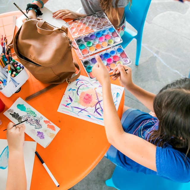 kids at a craft table working on watercolor paintings