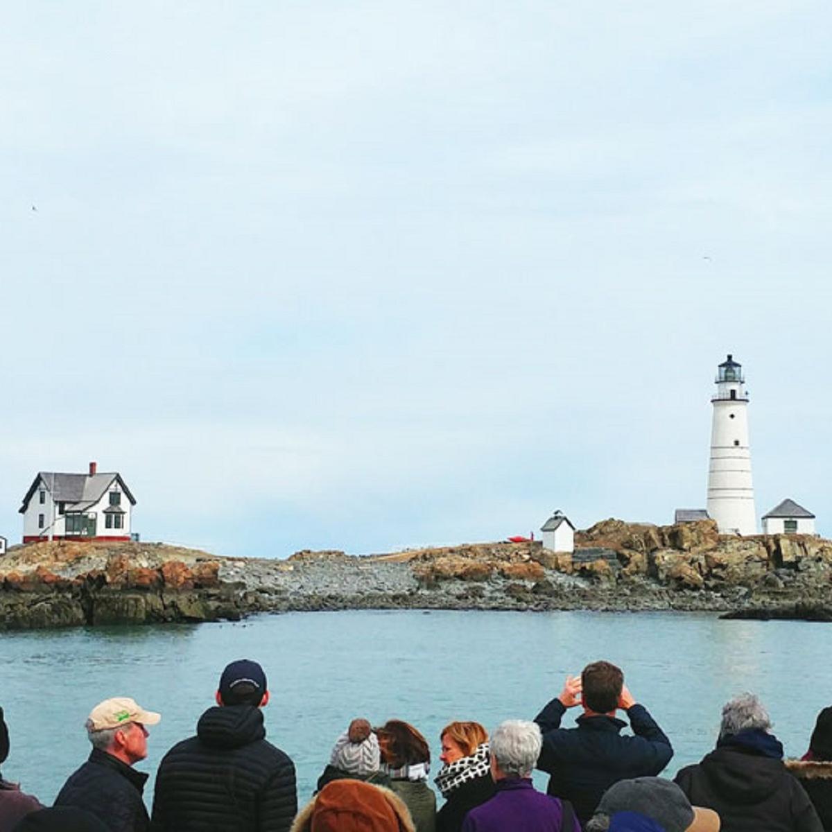 cruise-goers taking pictures and looking at Boston Light.