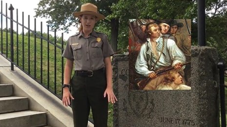 Ranger standing next to a granite marker on staircase with an image overlaid on the video.