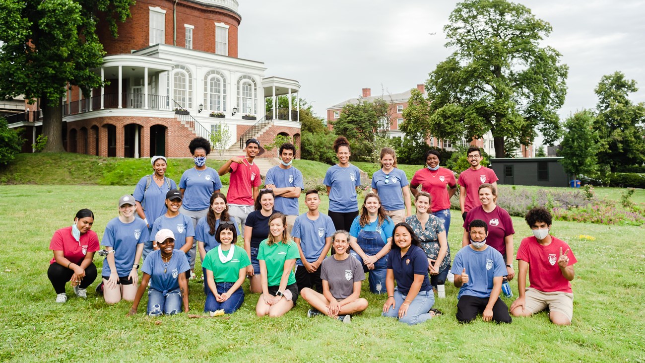 Group of youth and their mentors standing or crouching for a group photo. 