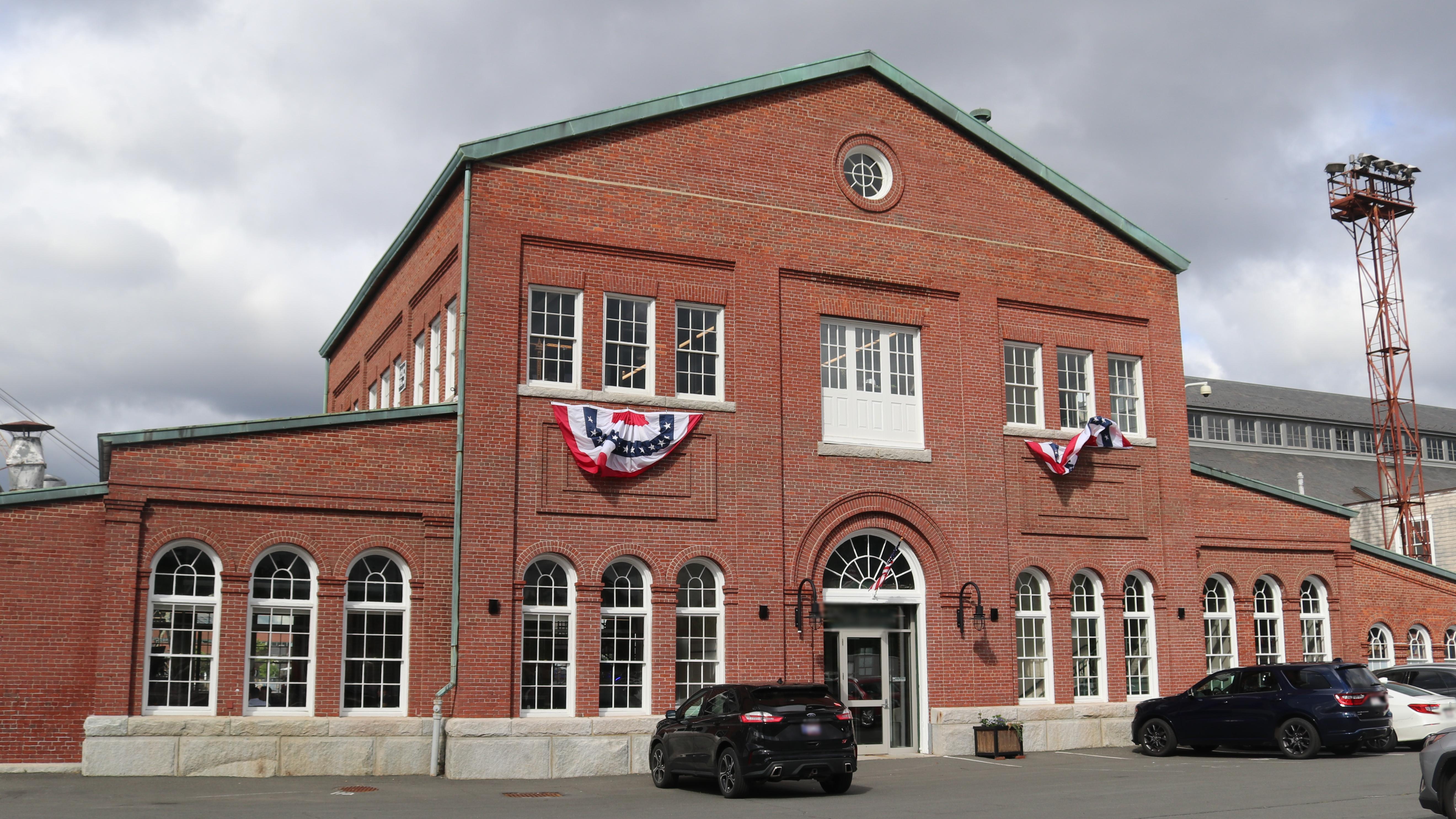 A brick building with a central 3-story structure and two one-story wings
